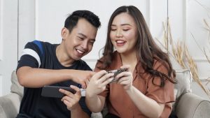Two people looking at their phones smiling.