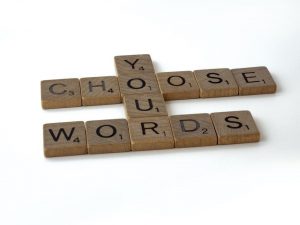 Scrabble tiles spelling "choose your words".